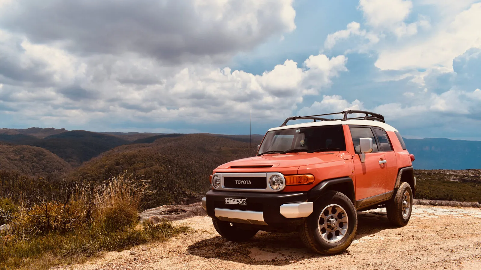 Talgat Zhangaziev (Tau) — founder and guide at Silk Travel, beside a 4×4